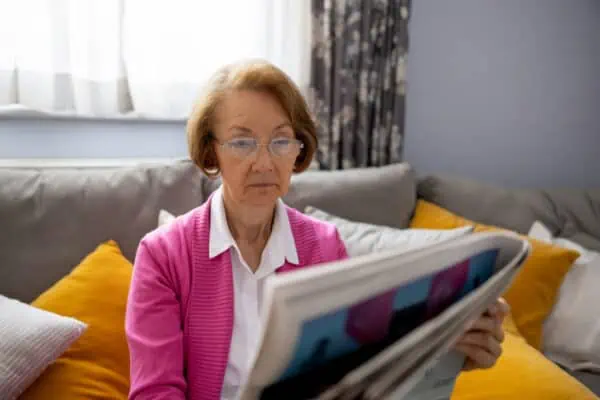 elder woman reading an obituary