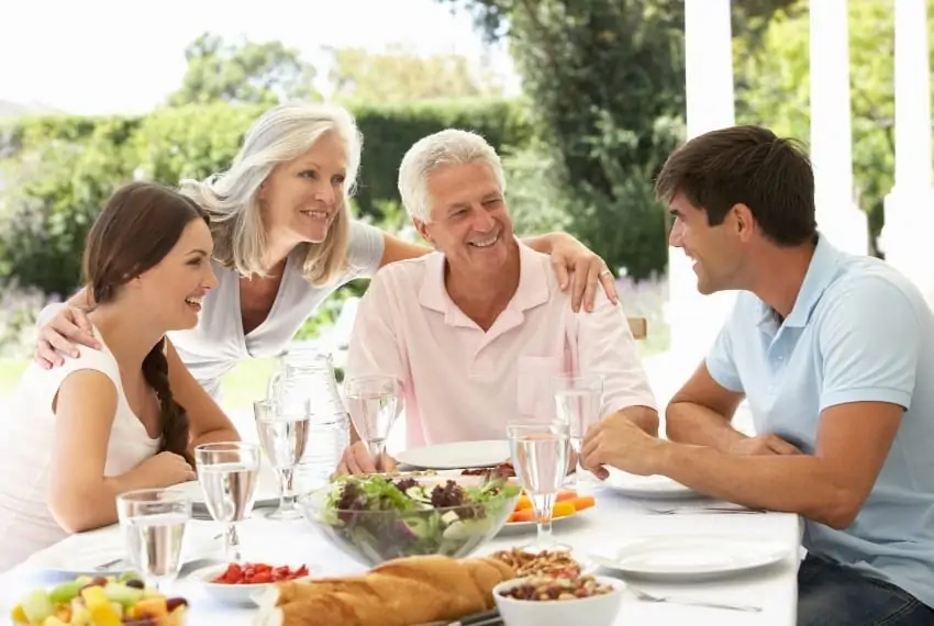 Grown children having lunch outdoors with their parents