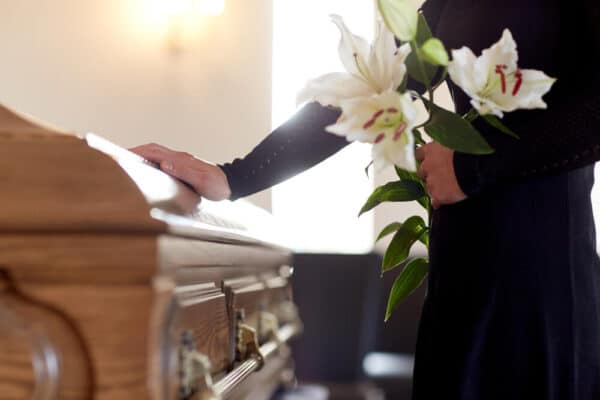 A person bringing flowers to a funeral