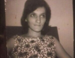 Black and white photo of woman with dark hair in patterned sleeveless top, sitting against a plain backdrop; ideal for illustrating compassionate funeral services, cremations, and pre-planning support in Alabama.