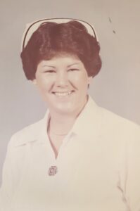 A smiling nurse in white at a funeral home in Alabama helps with cremation services.