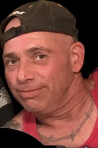A man in a red tank top, for Alabama funeral and cremation service obituaries.