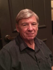 Older man with gray hair in dark shirt at funeral home, Alabama, for obituaries and cremation services.