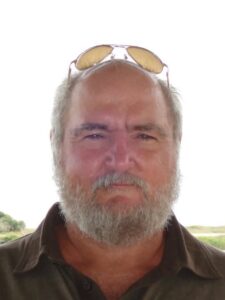 A middle-aged man outside a funeral home in Alabama, reflective about cremation services and burial options.