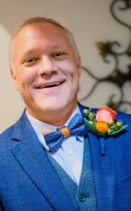 A man in a blue suit at an Alabama funeral home offers cremation and burial services.