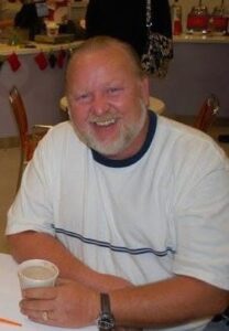 Smiling man at a table in Alabama funeral home discussing cremation services and costs.