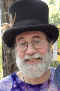 Smiling man in black top hat at Alabama funeral home, cremation and burial services.