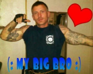 A tattooed man poses in a sleeveless shirt; "MY BIG BRO" text relates to Alabama obituaries, funerals, cremation services, funeral home costs.