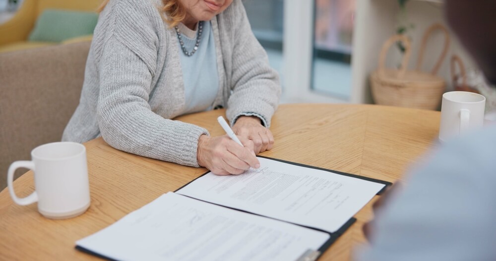 A woman completes a funeral planning guide to pre-plan her services.