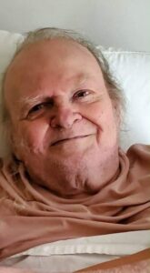 An elderly person in bed at an Alabama funeral home, smiling, representing cremation services and funerals.