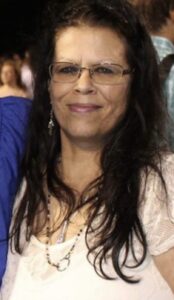 Smiling woman at Alabama funeral home, offering cremation services and burial advice.